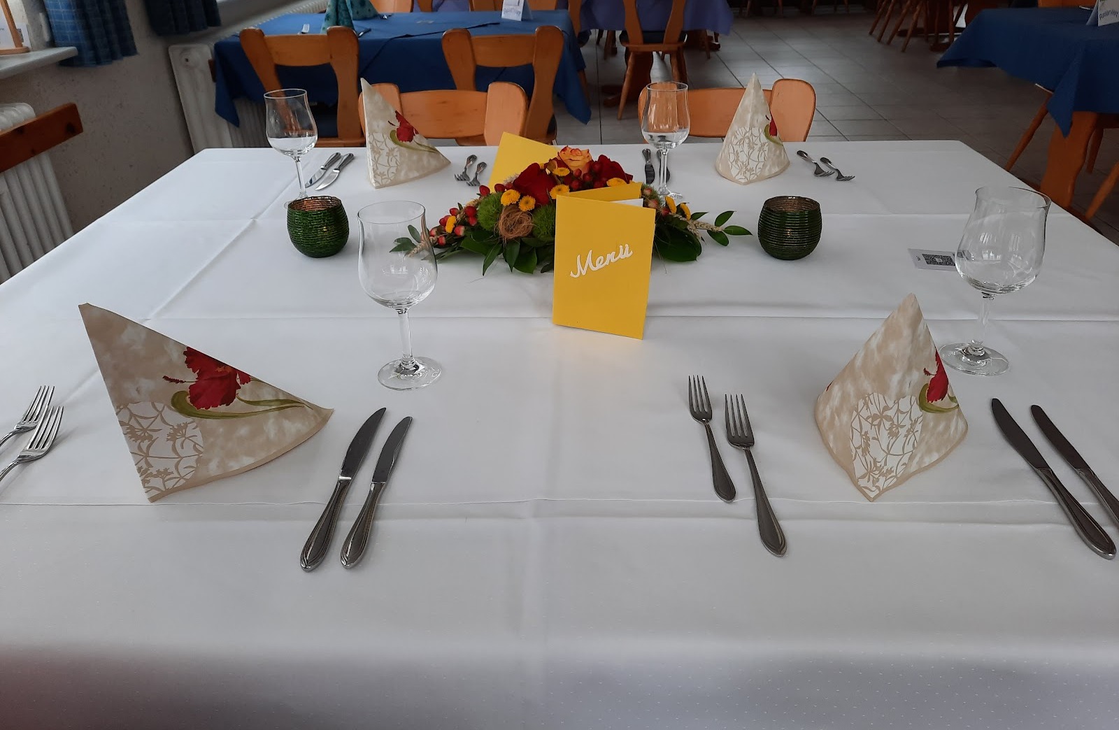 Eingedeckter Tisch mit Blumengesteck und Menükarte